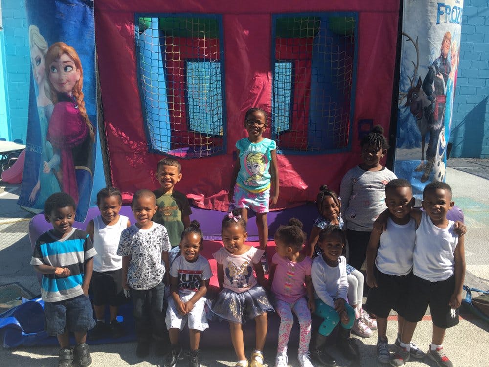 Group of children posing in front of a bounce house