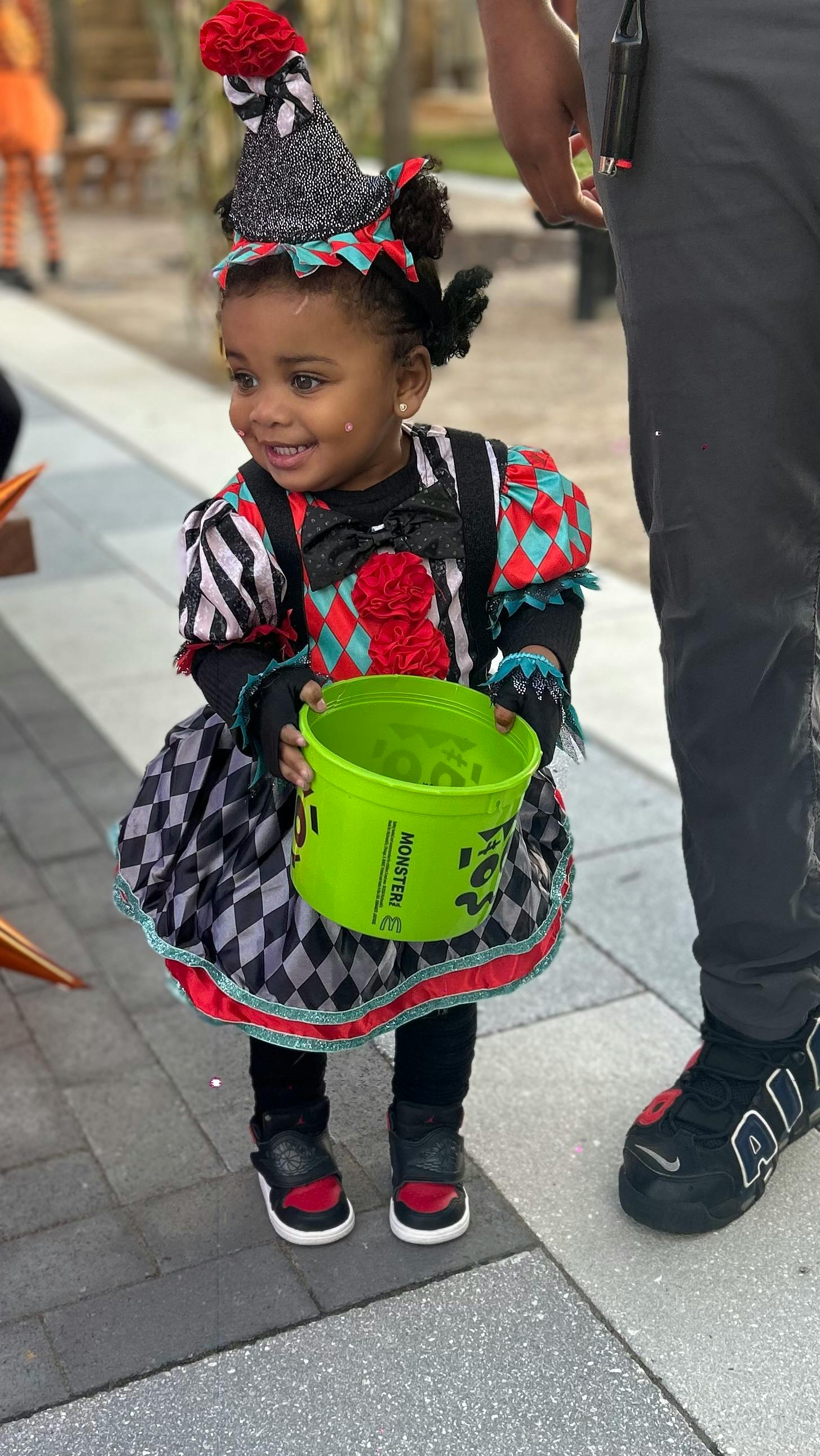 Child in costume holding a green bucket