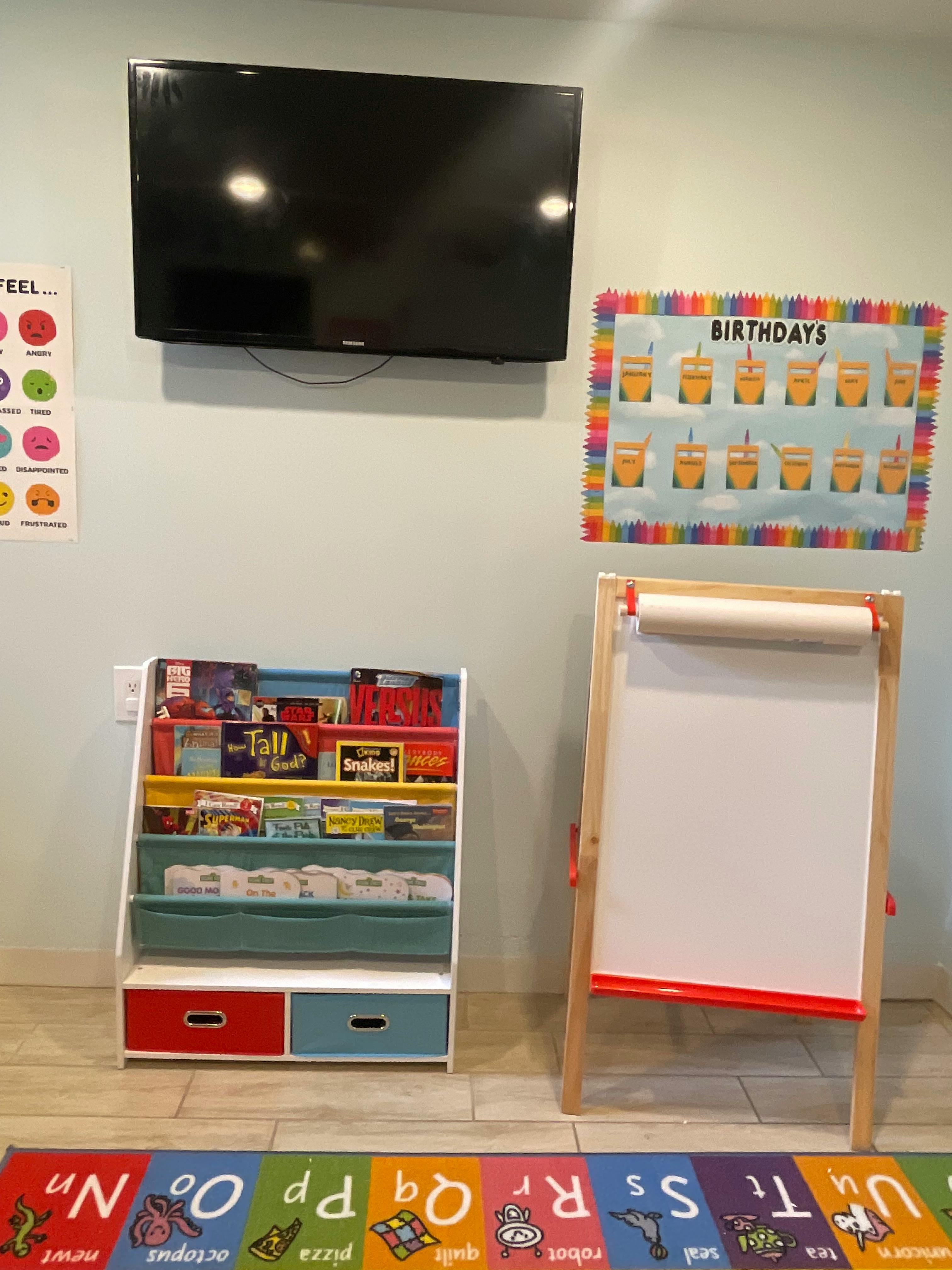 Bookshelf, easel, and TV in a classroom