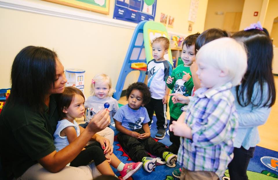 Adult and children interacting in a classroom