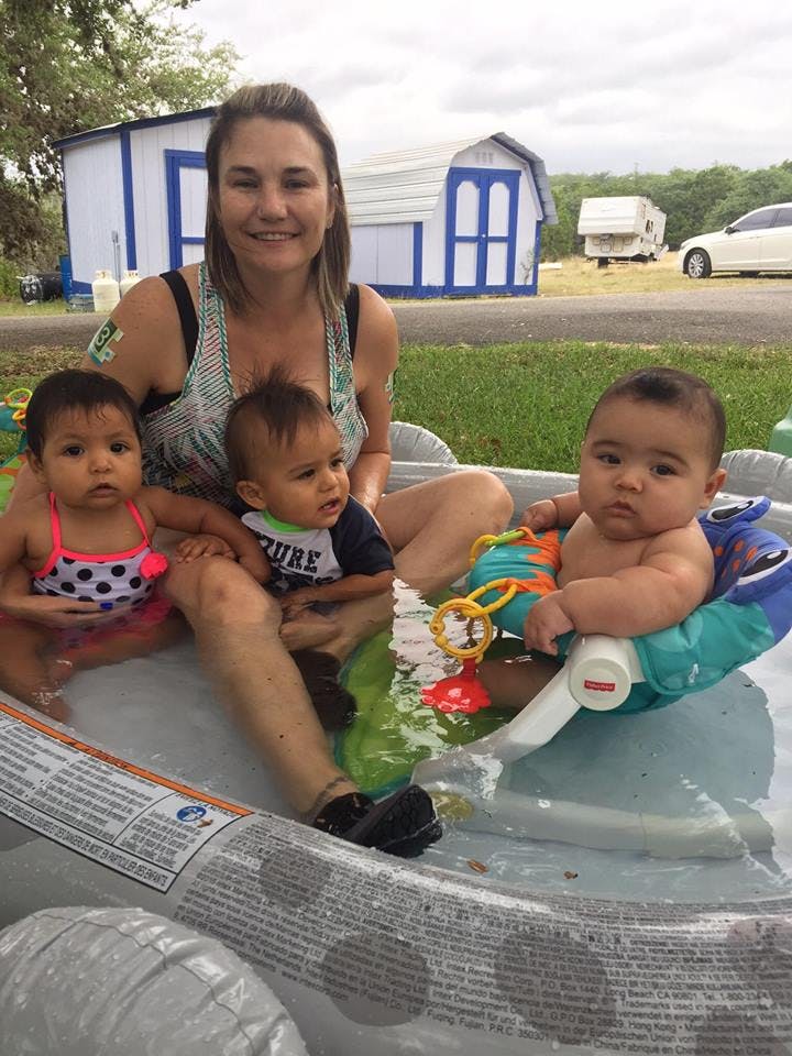 Person and three children in an inflatable pool