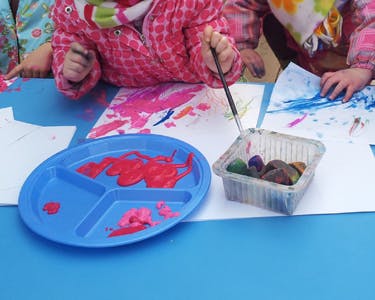 Child painting on paper with a brush