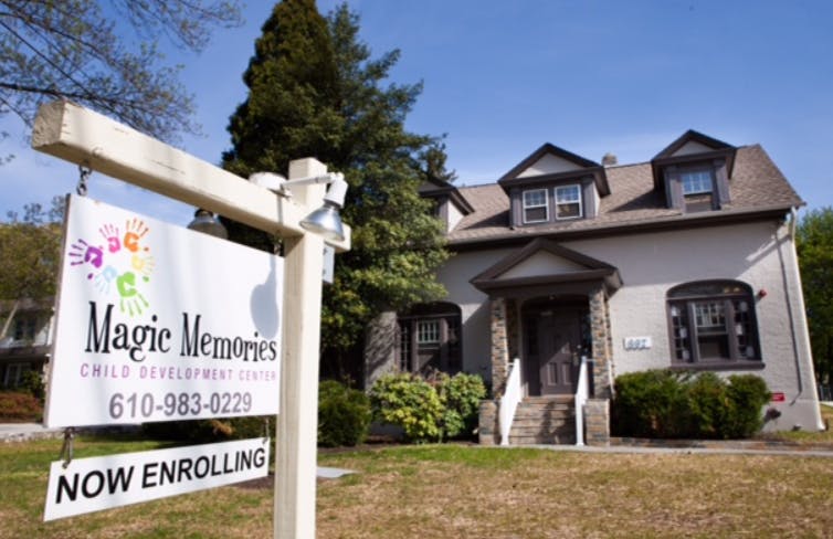 Sign for Magic Memories Child Development Center with a building in the background