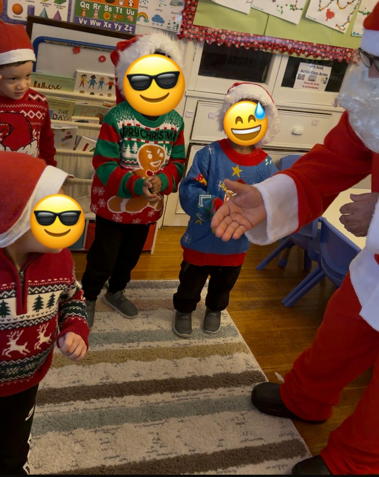Children in Santa hats and holiday sweaters with a person dressed as Santa