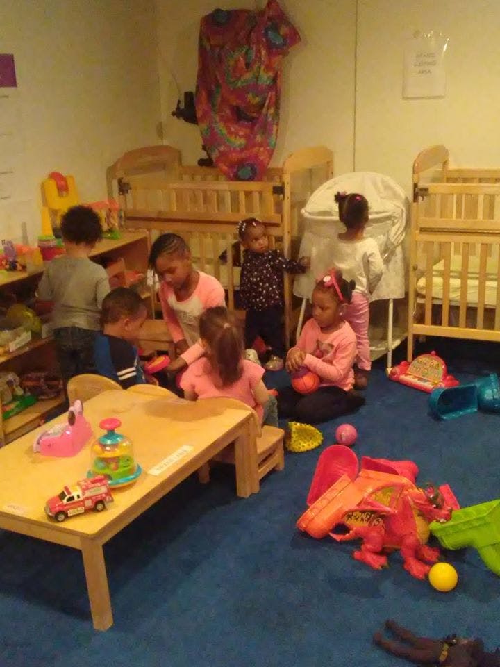 Children playing in a room with cribs and toys