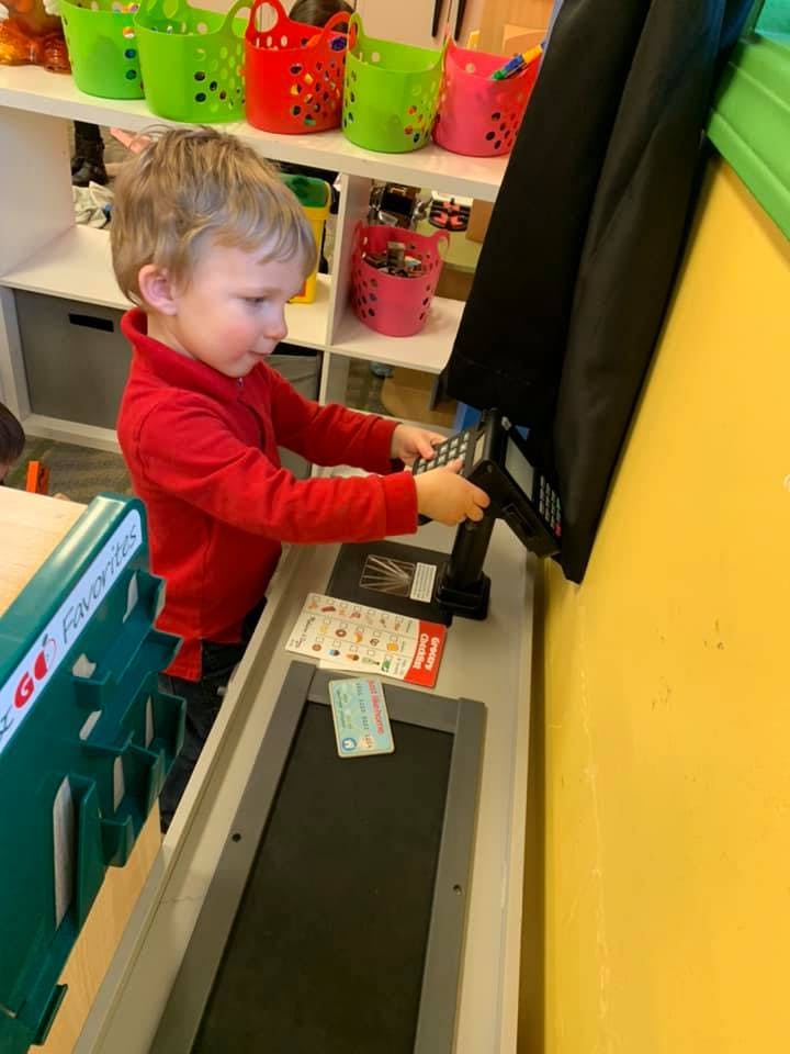 Child playing with a toy cash register