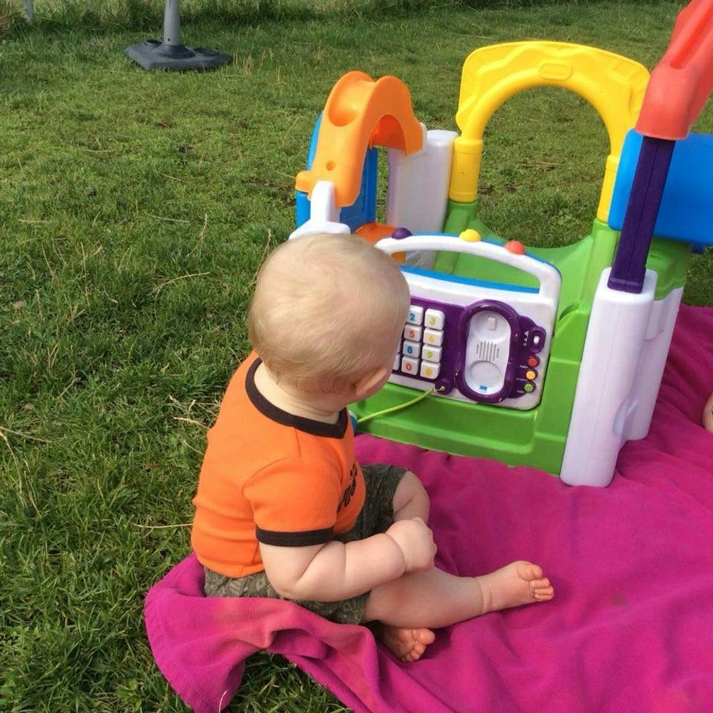 Child sitting on a blanket playing with a toy