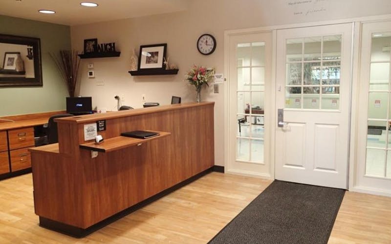Reception desk with a computer and shelves with decorations