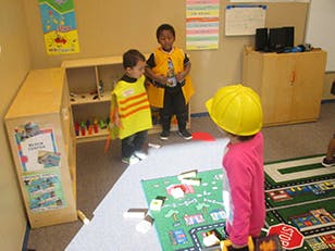 Three children playing in a classroom