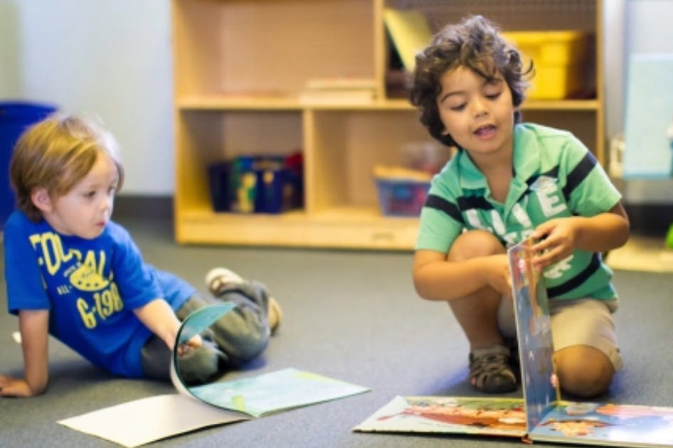 Two children on the floor looking at books