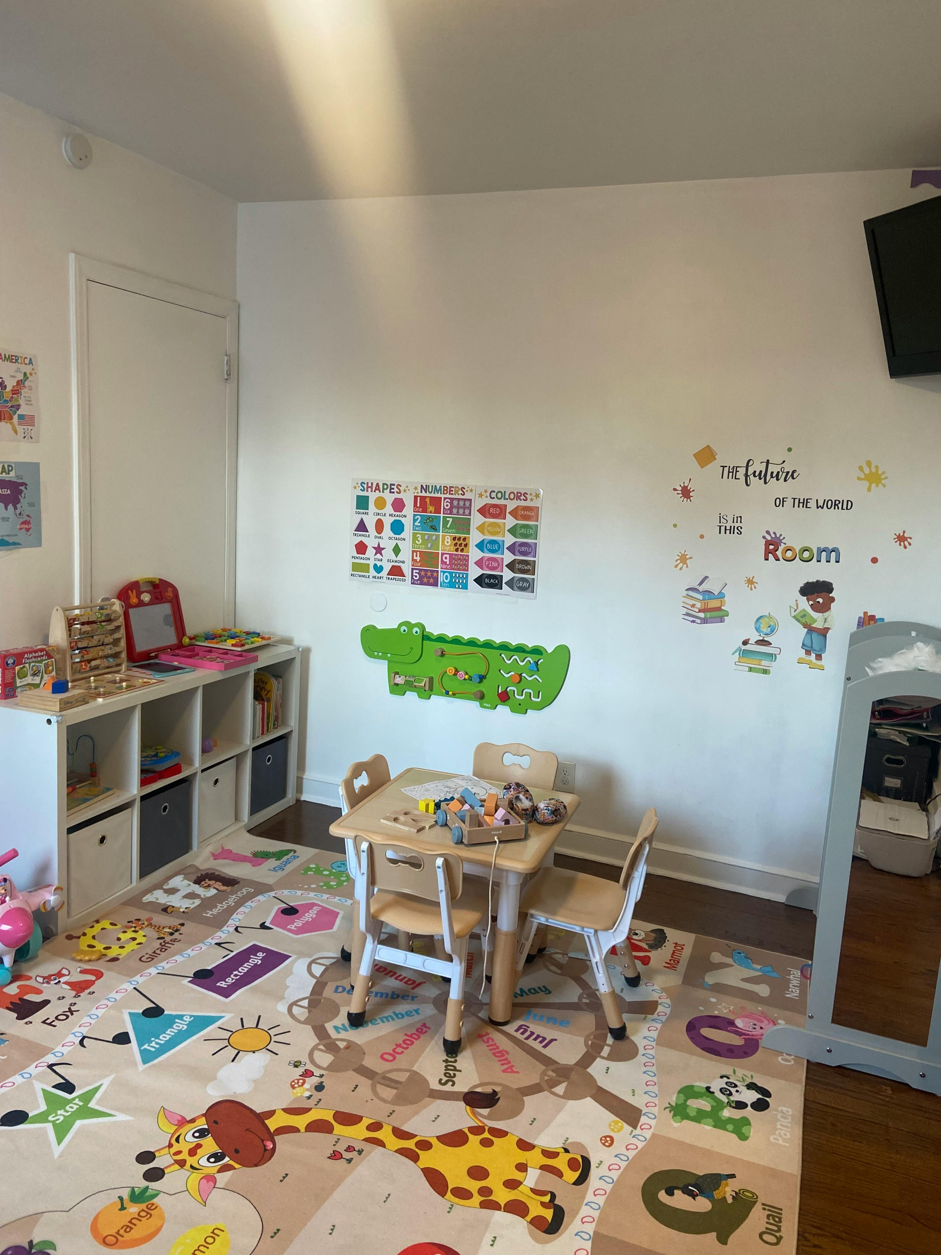 Playroom with small table and chairs, toy storage, and colorful rug