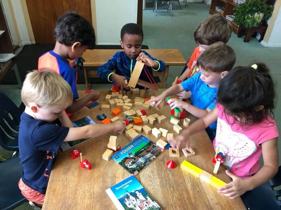 Children playing with wooden blocks at a table