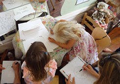 Three children drawing at a table