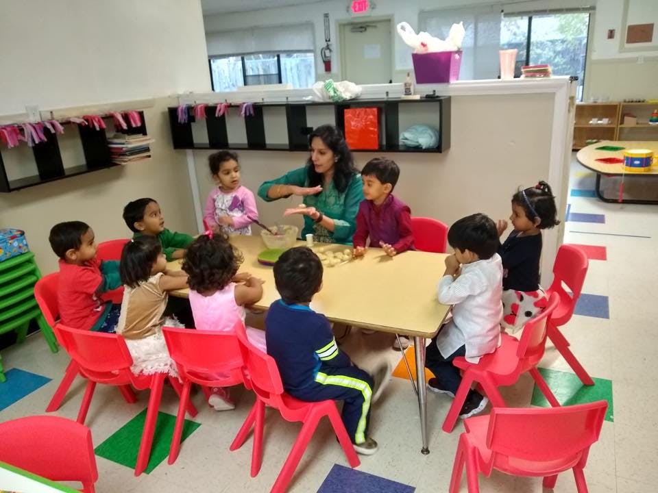 Adult and children sitting around a table in a classroom