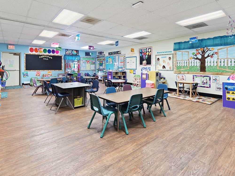 Classroom with small tables and chairs, and decorations on the walls