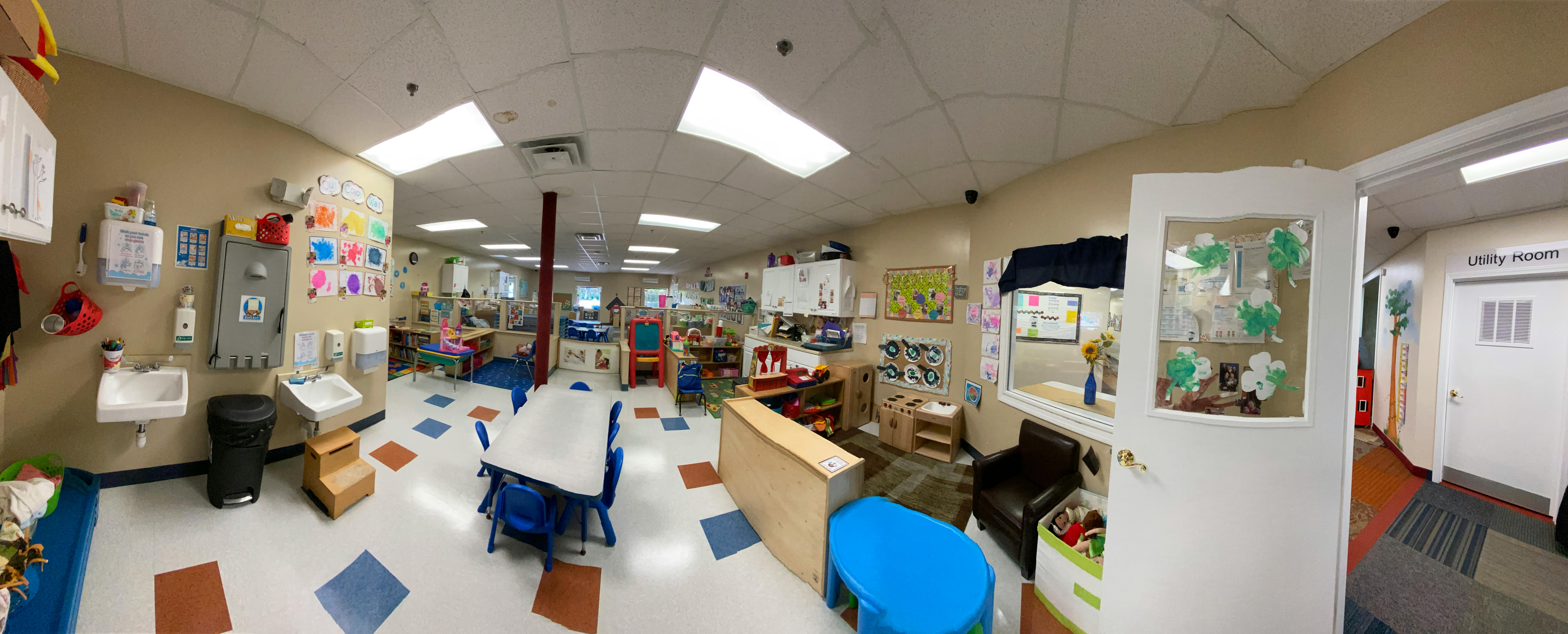 A classroom with small tables and chairs, and various learning materials
