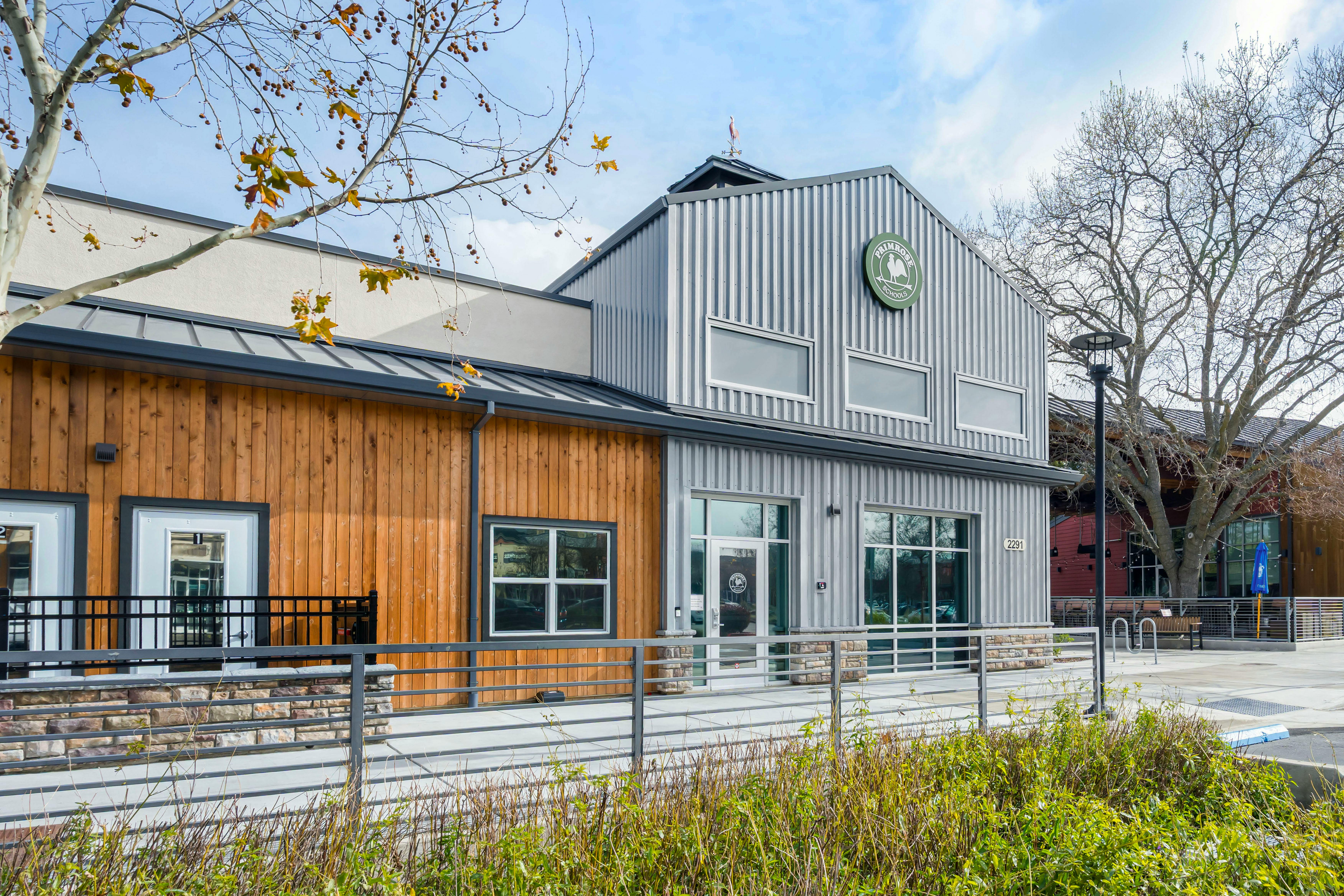 A modern building with wood and corrugated metal siding and a "Primrose Schools" sign