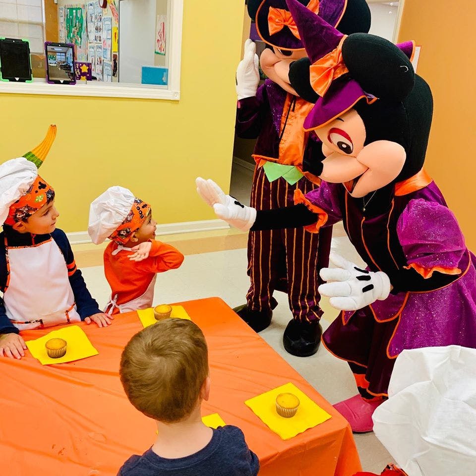 Children in chef hats looking at costumed characters