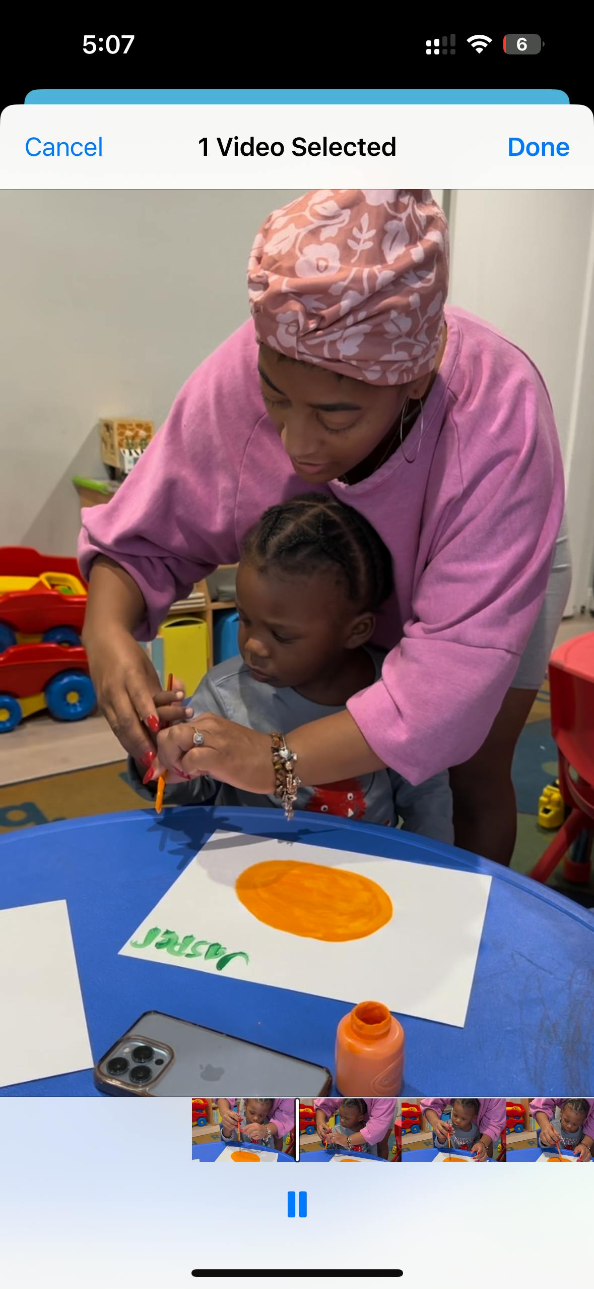 Person helping a child draw on paper with crayons on paper