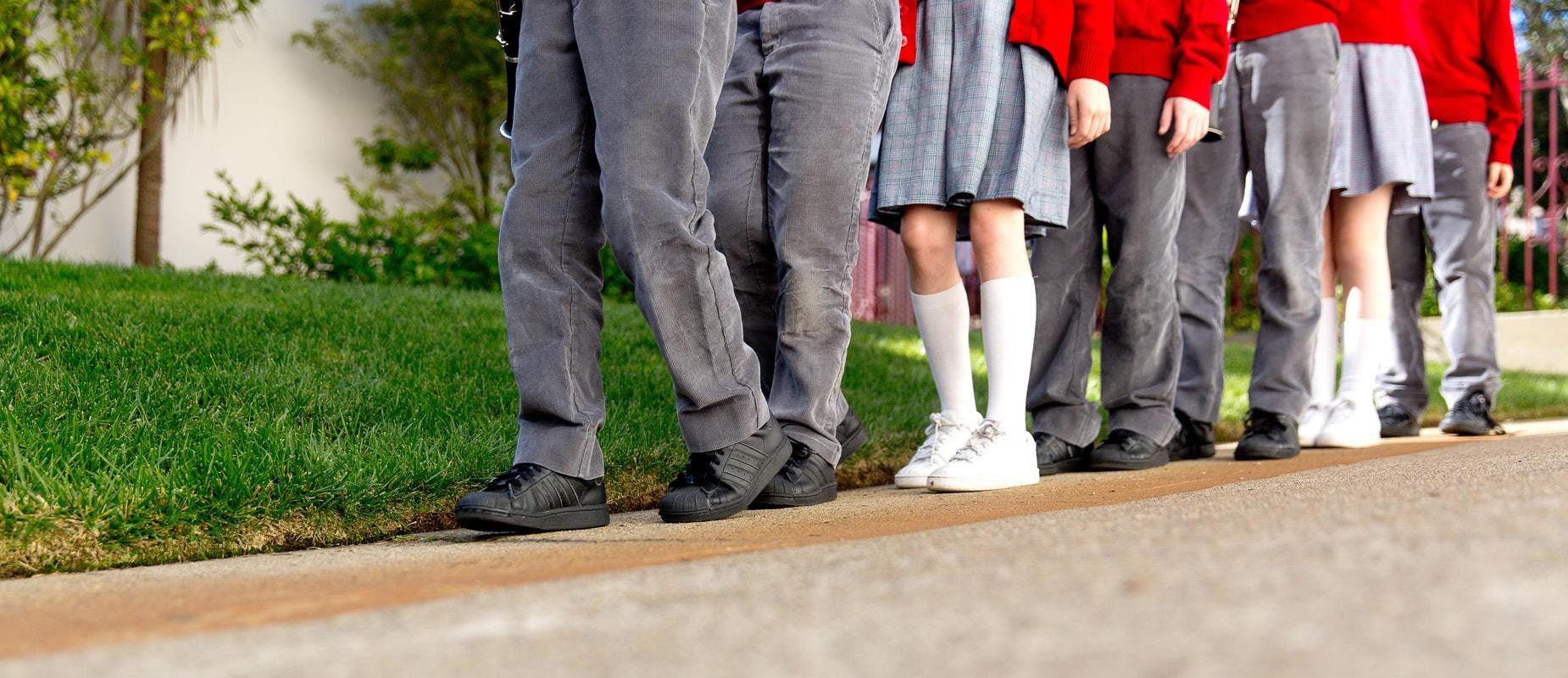 Group of children standing in a line outdoors in a line