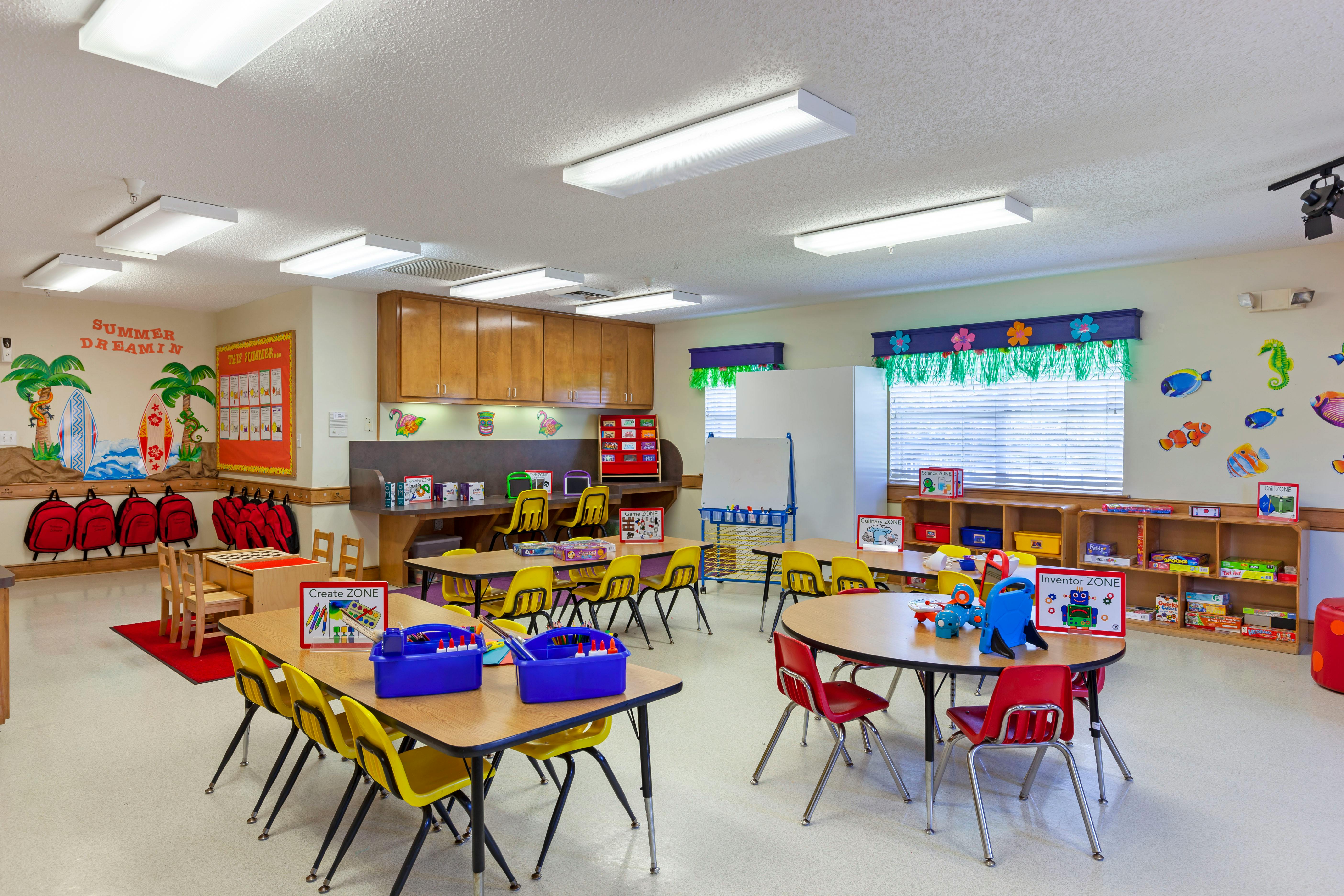 Classroom with tables and chairs, activity stations, and summer-themed decorations
