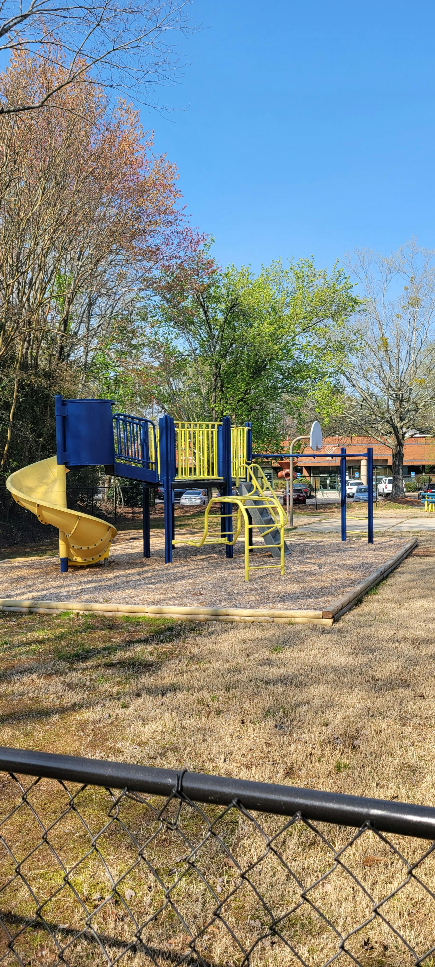 Playground with blue and yellow equipment on wood chips