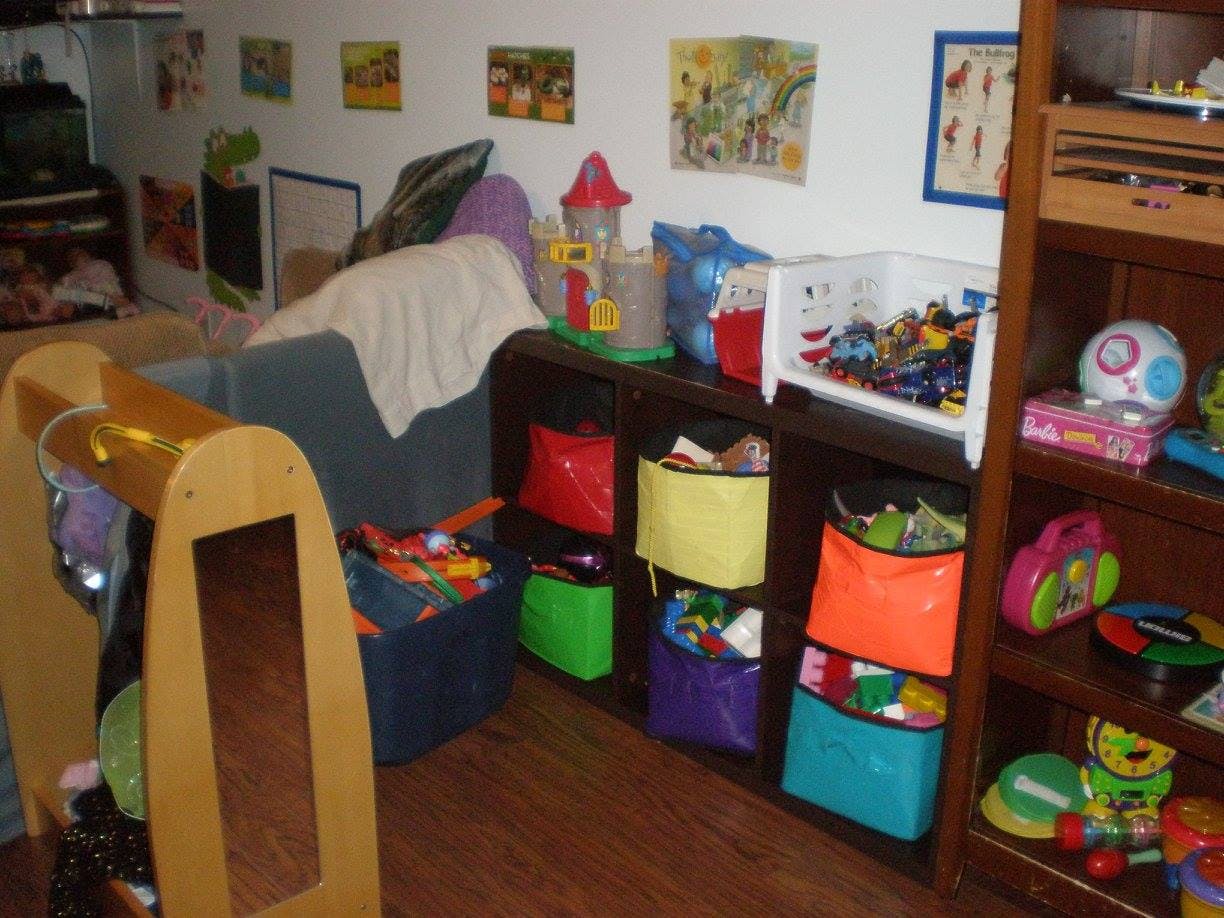 Playroom with toys, storage bins, and a small couch