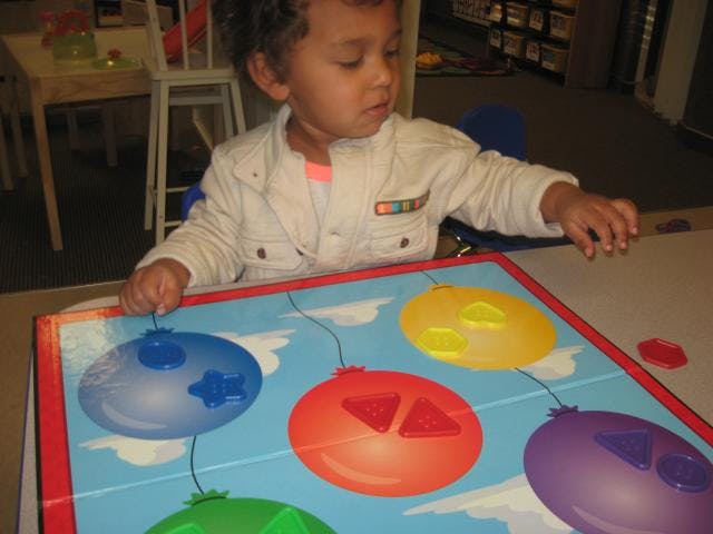 Child playing with a balloon-themed board game