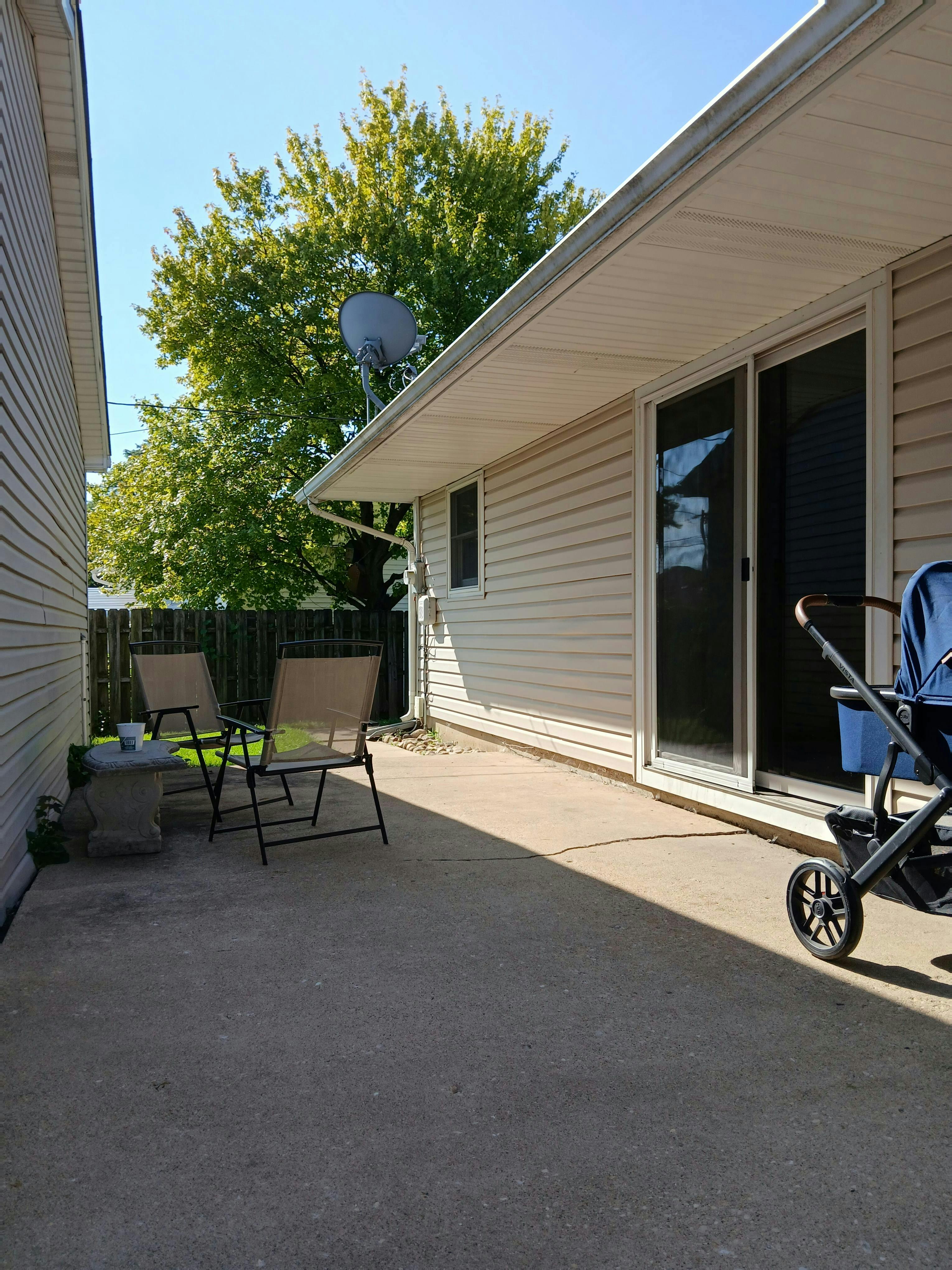 Chairs and a stroller on a residential concrete patio