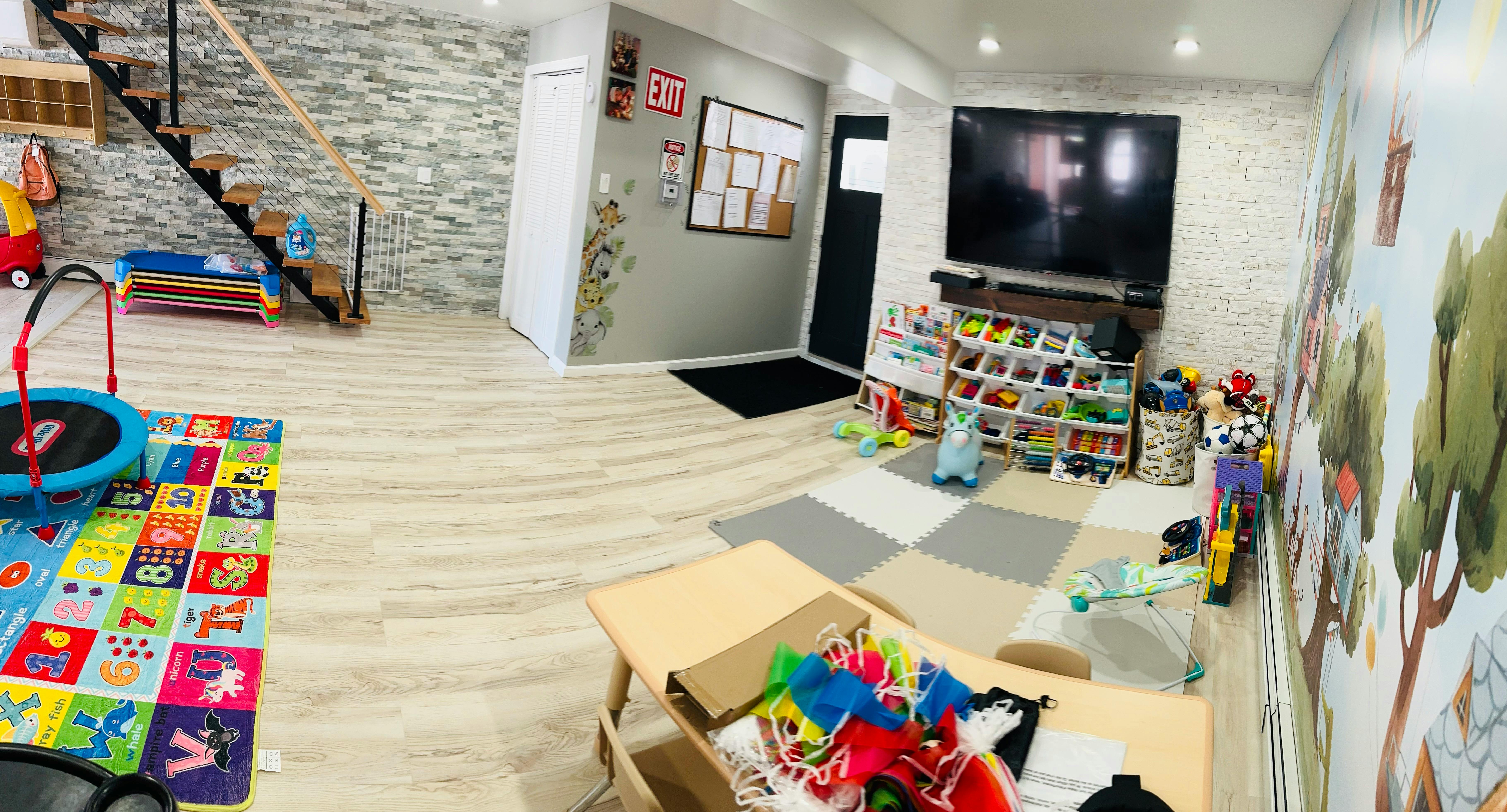 Indoor play area with toys, a small trampoline, and a staircase