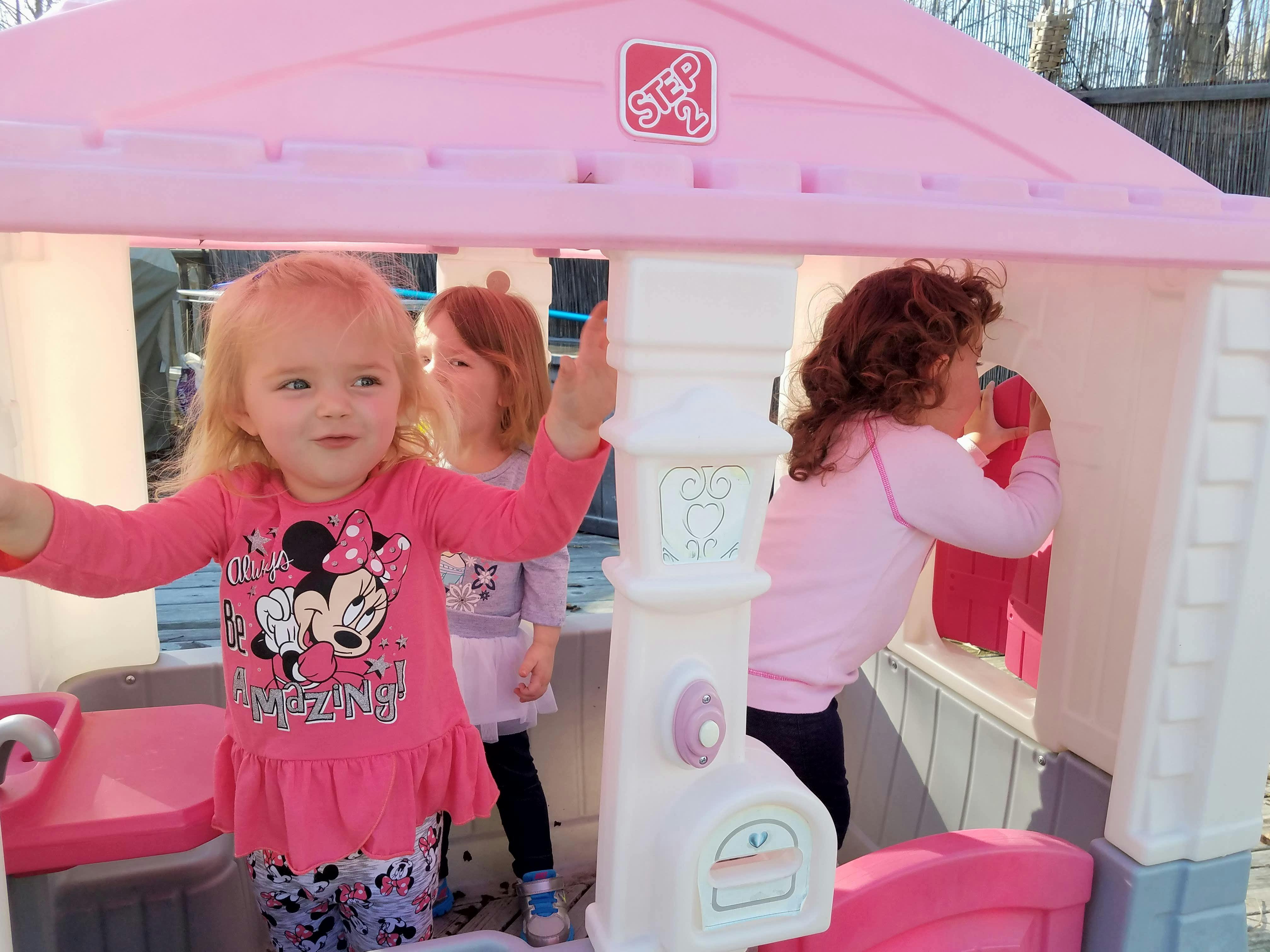 Children playing in a pink playhouse