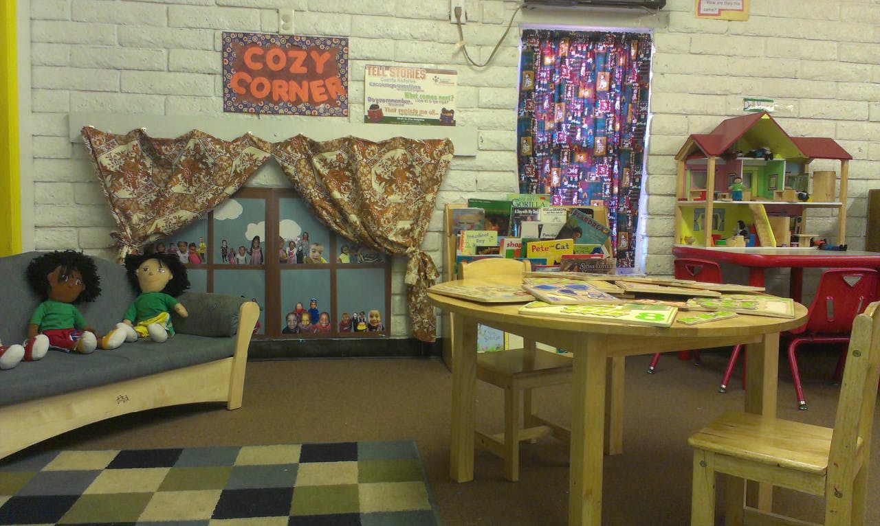 Playroom with a couch, table and chairs, and a dollhouse