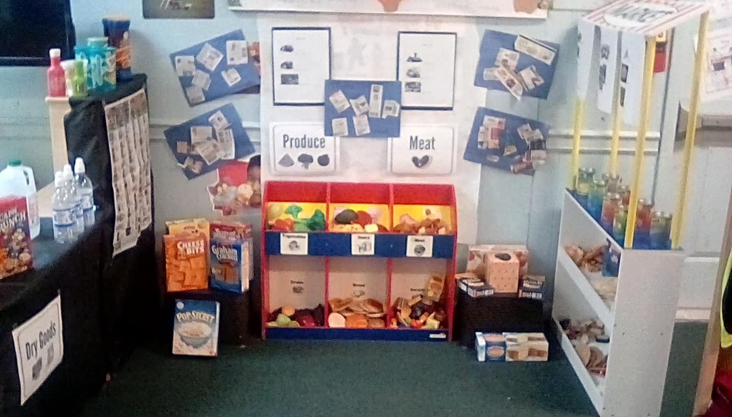 Classroom with play food market display and shelves of shelves of items