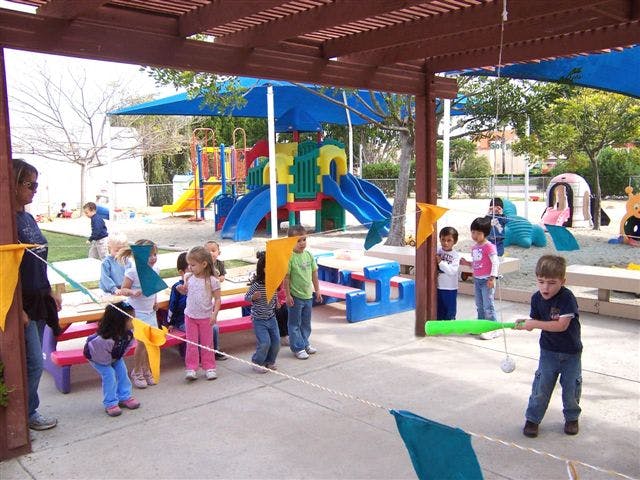 Children playing with a tee-ball set on a playground
