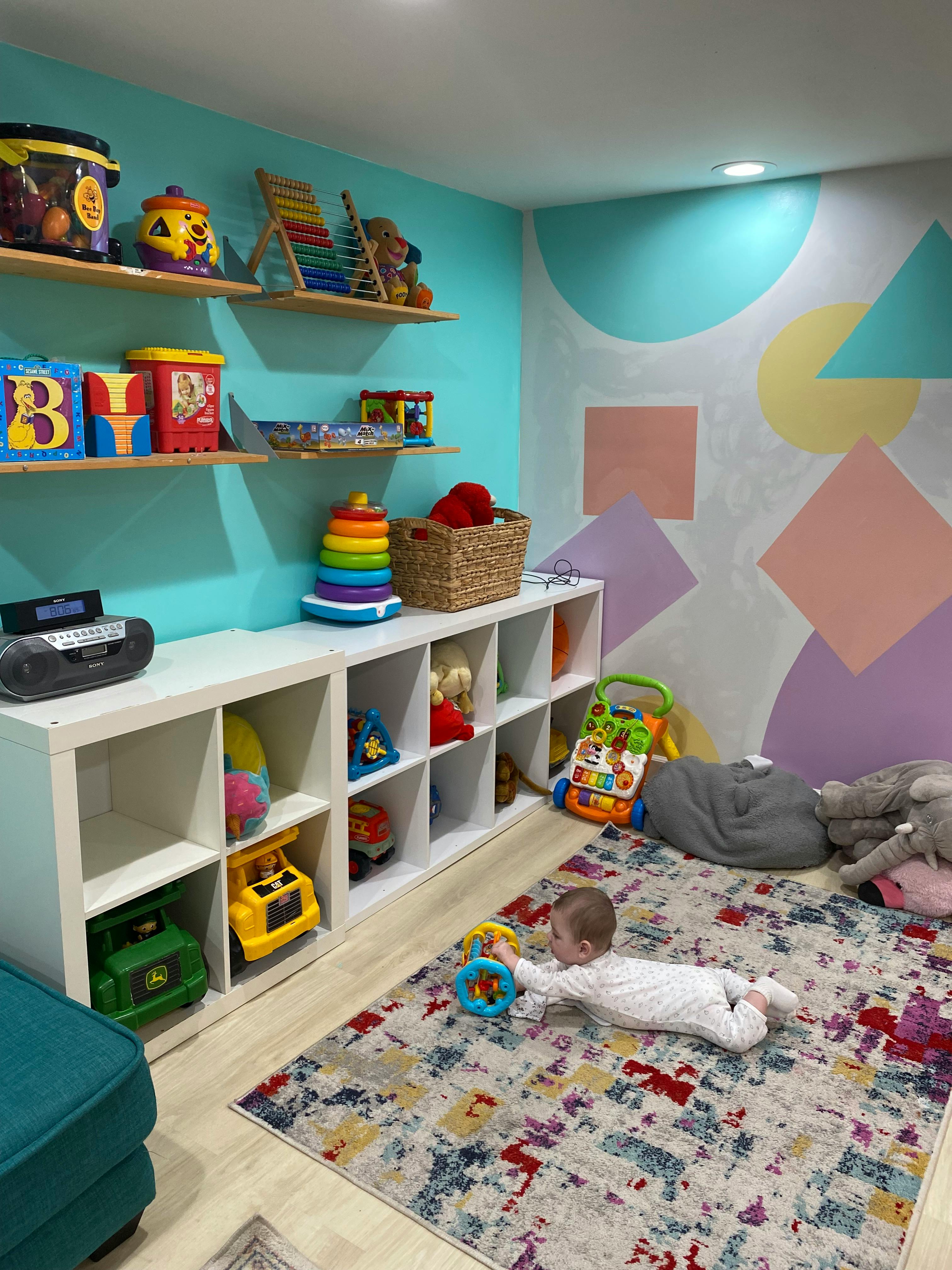 Child on a rug playing with a toy in a room with shelves of toys