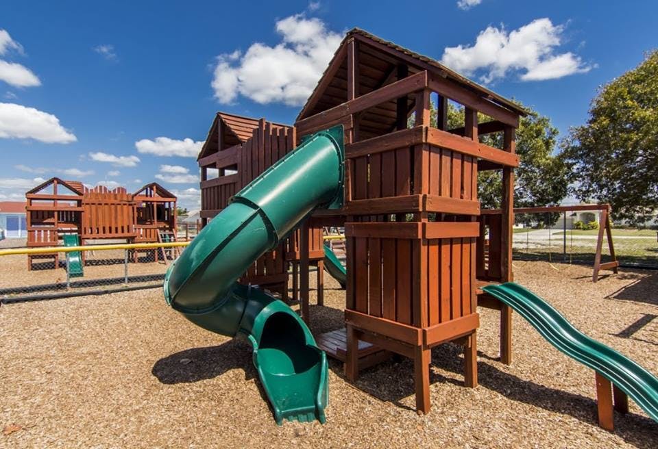 Playground with wooden structures and green slides