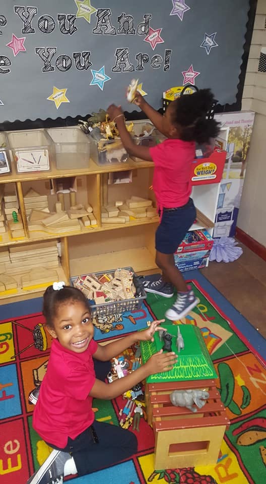 Two children playing with toys in a classroom