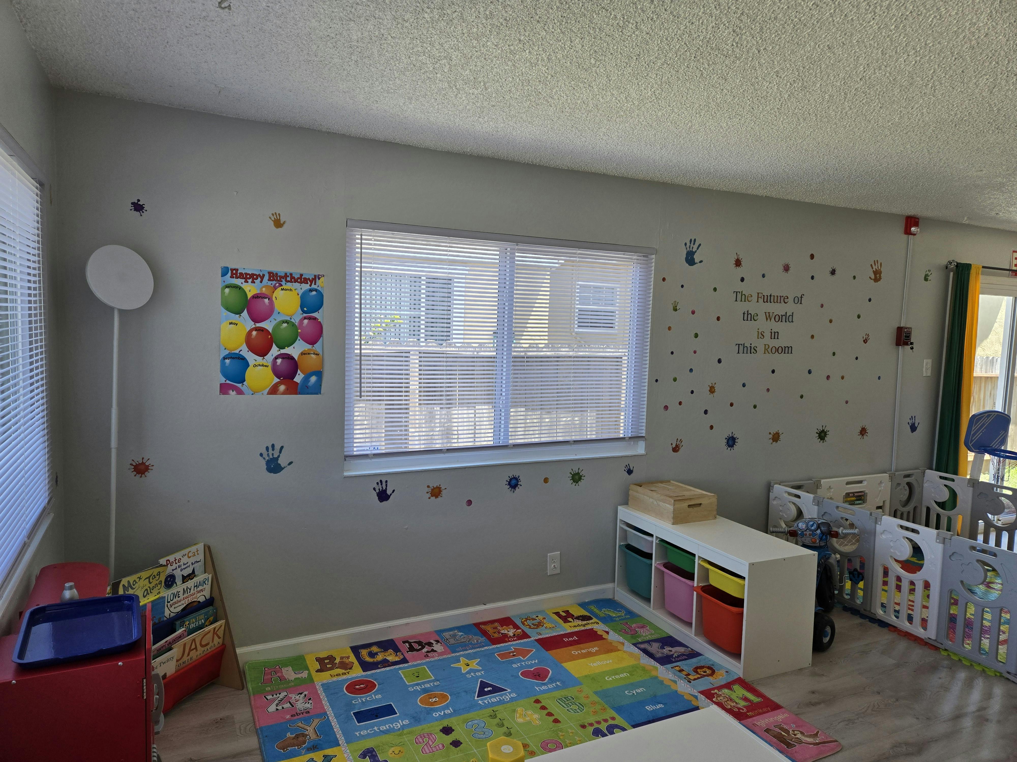 Playroom with colorful rug, window, and storage unit