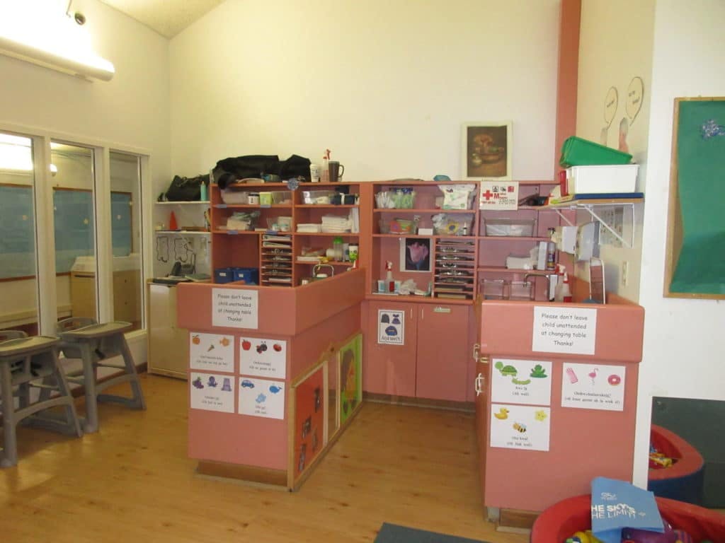 Classroom with pink storage units and shelves filled with supplies