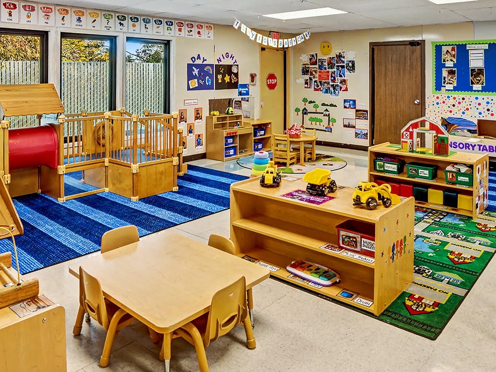 Colorful classroom with play structures, toys, and small tables
