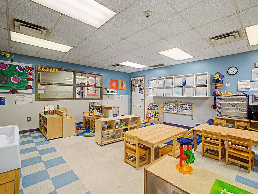Classroom with small wooden tables, chairs, and learning materials