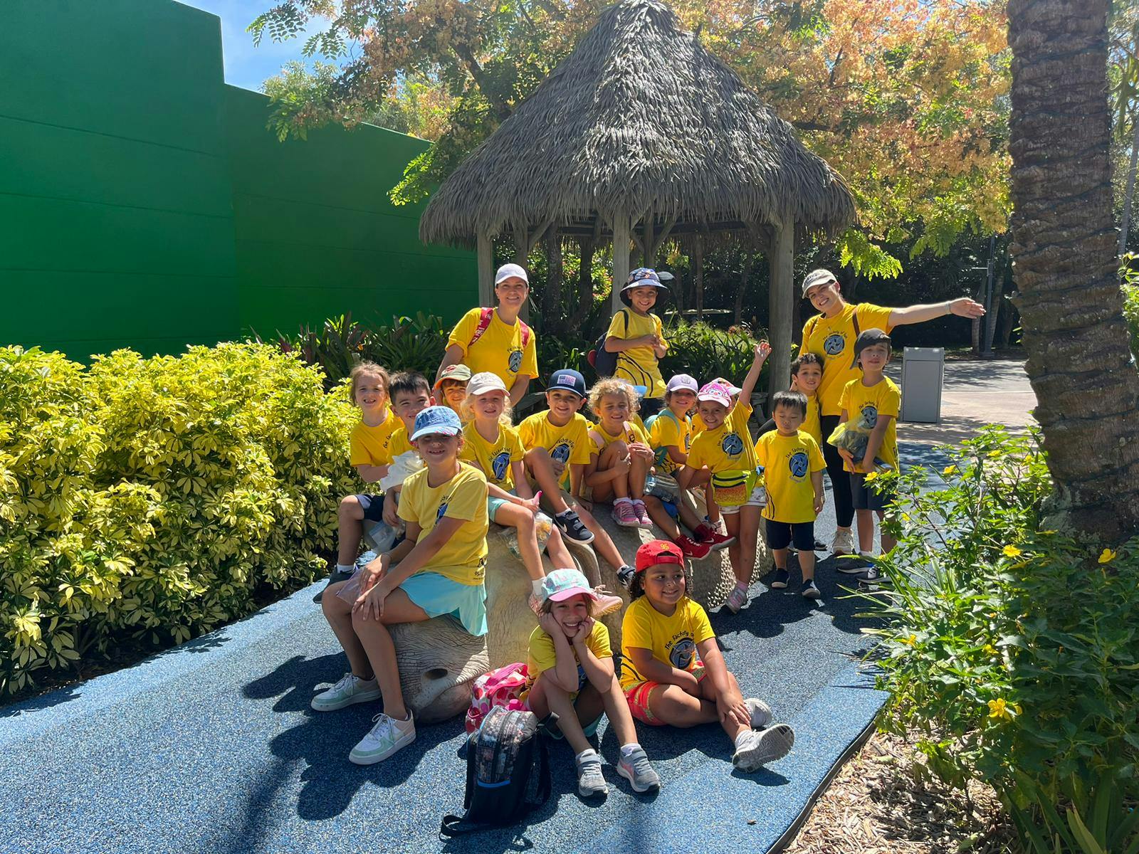 Group of children and adults in yellow shirts posing outdoors
