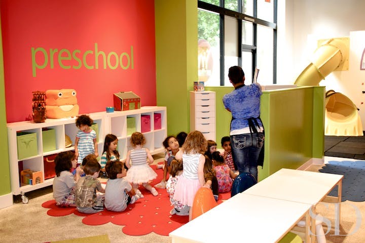 Adult teaching a group of children in a preschool classroom