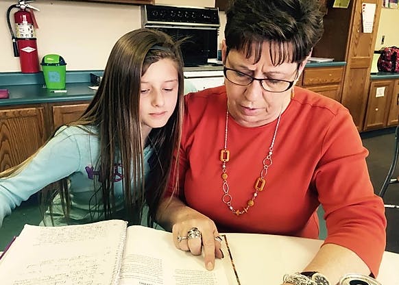 Adult and child reading a book together