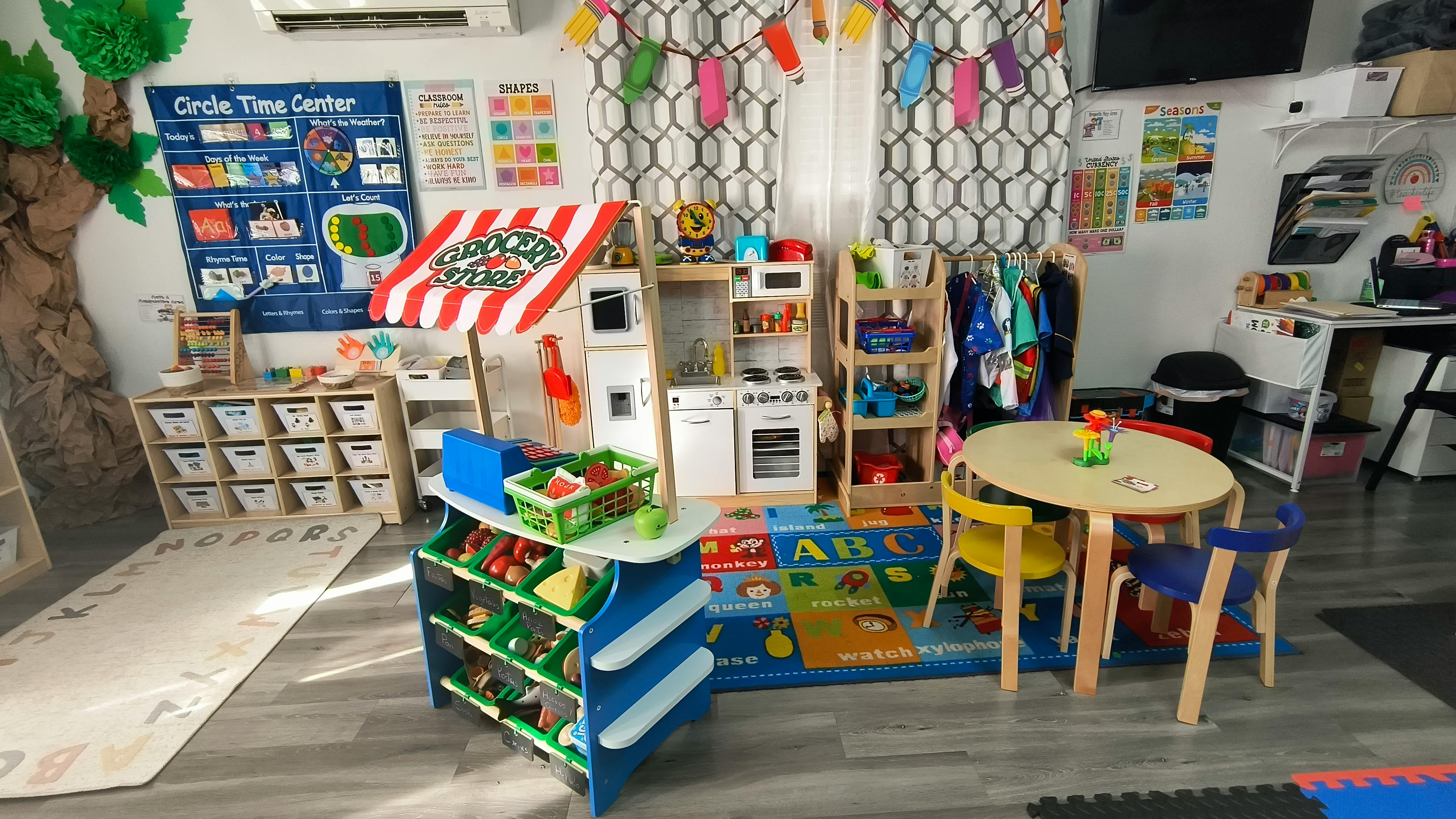 Toy grocery store and kitchen set in a classroom play area