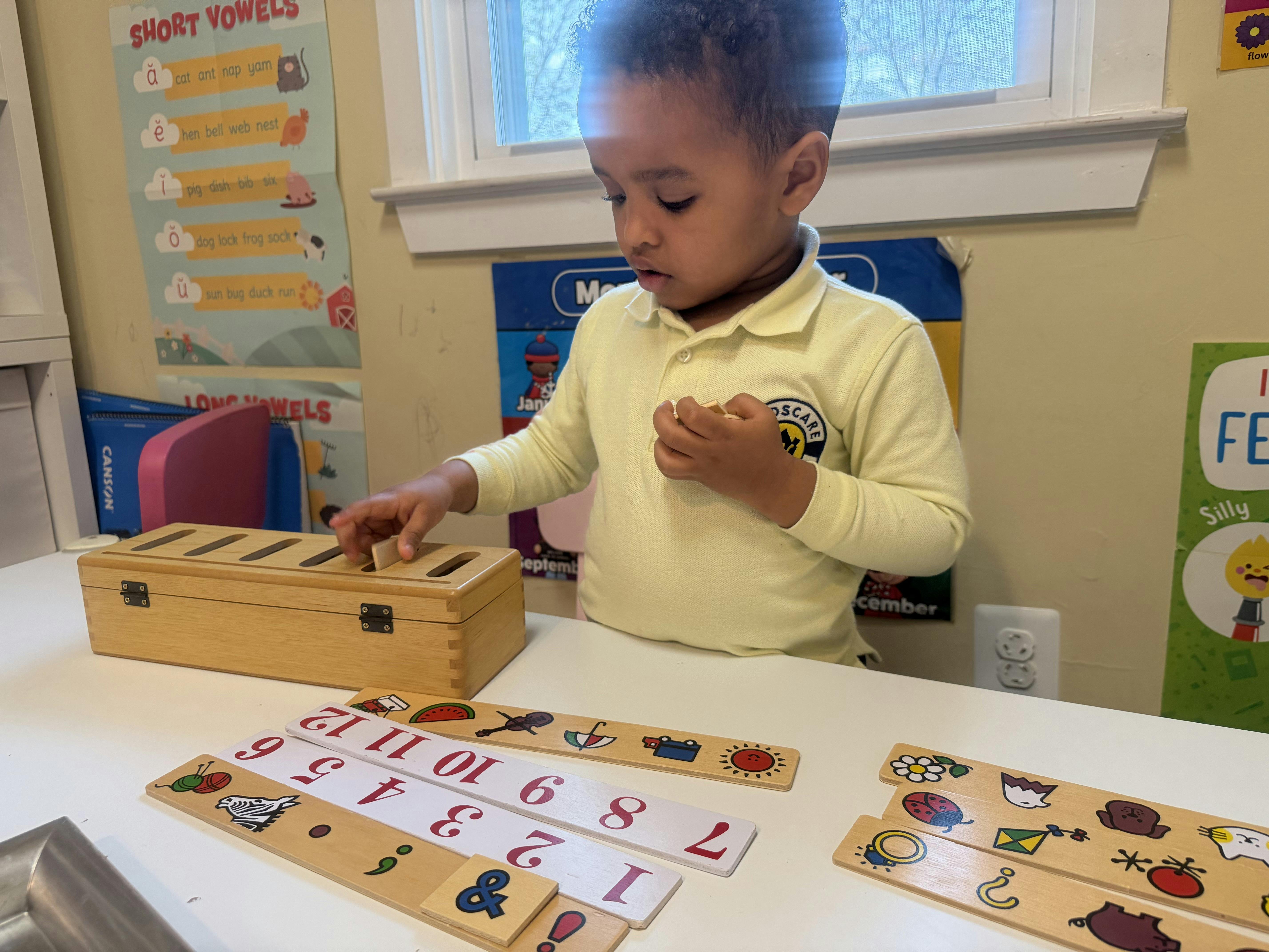 Child playing with a wooden matching game in a classroom