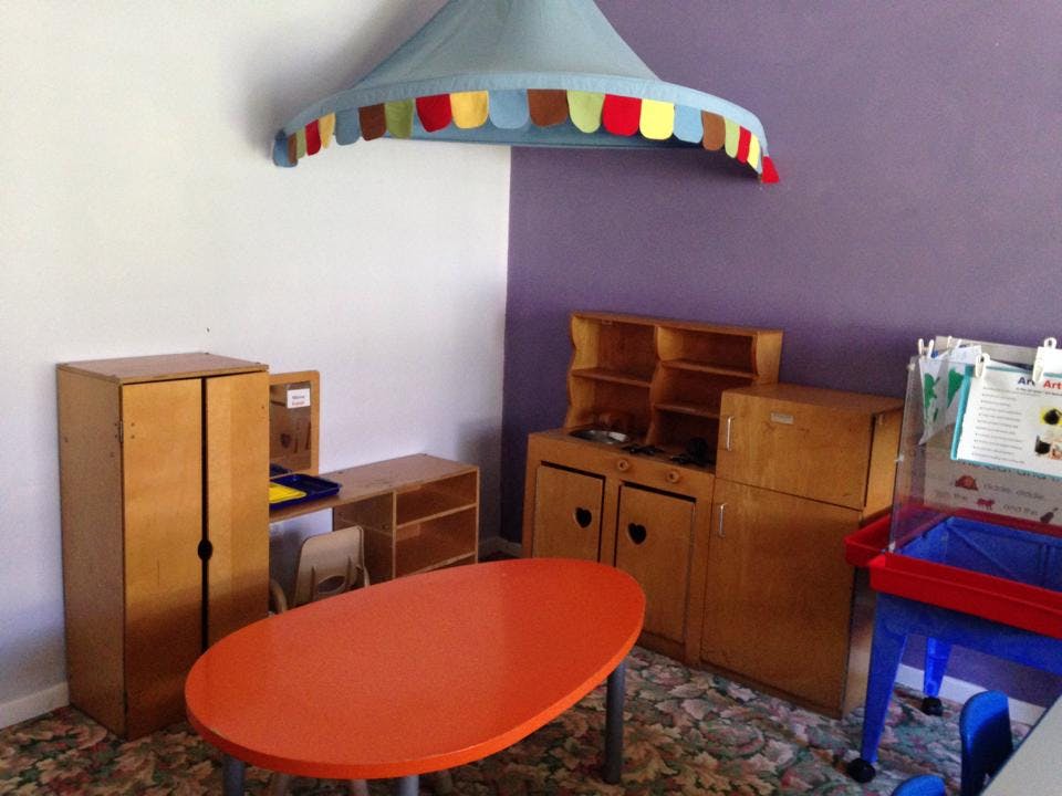 Playroom with toy kitchen, table, and canopy