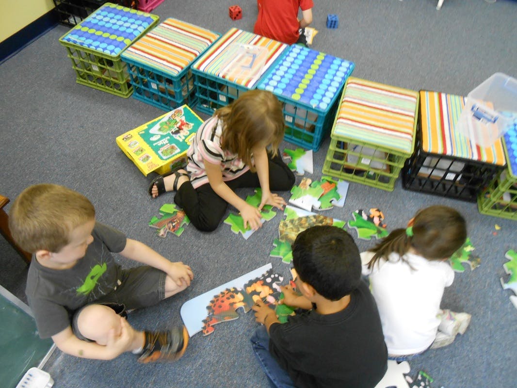 Children sitting on the floor doing puzzles