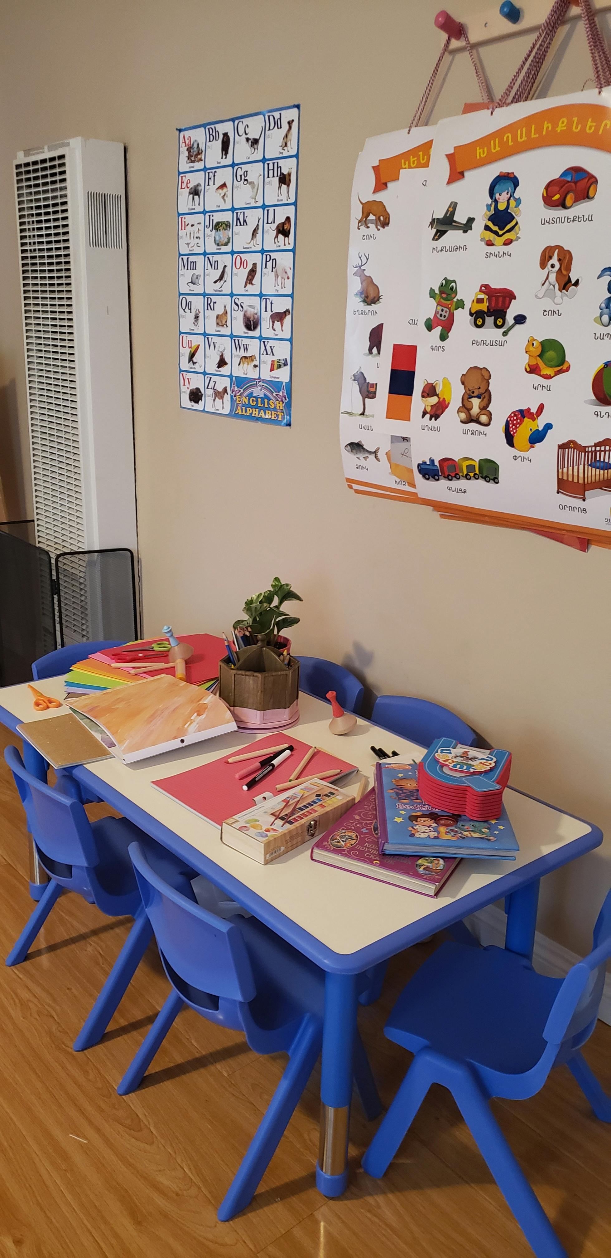 Children's table with blue chairs and school supplies