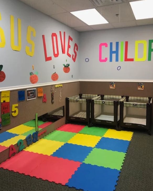 Nursery room with play mats, cribs, and wall decorations